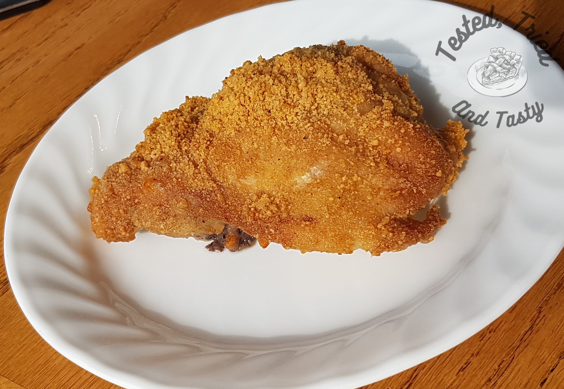 parmesan and garlic shake n bake chicken on a white plate.