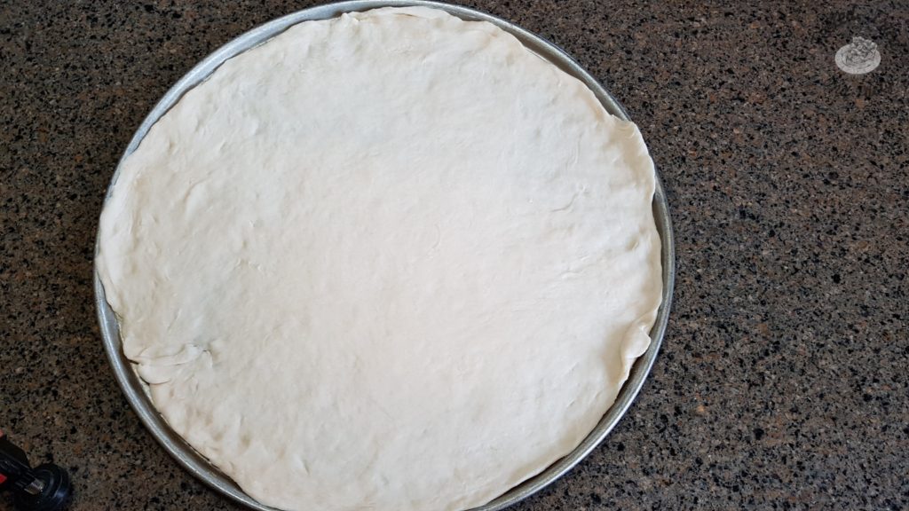Pizza dough recipe on a pizza pan.