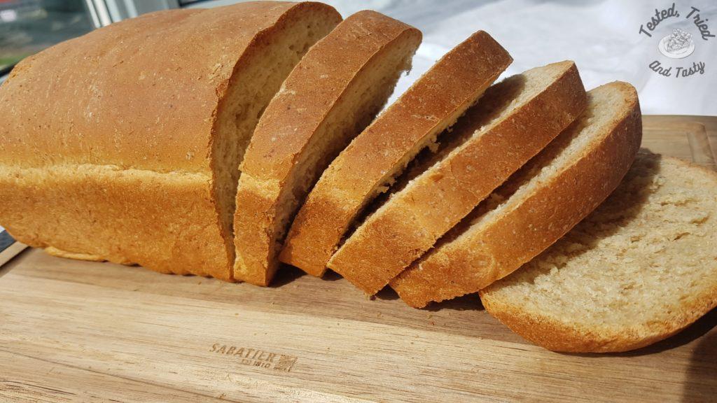 Almost Whole Wheat Bread on a wooden cutting board on a white table cloth
