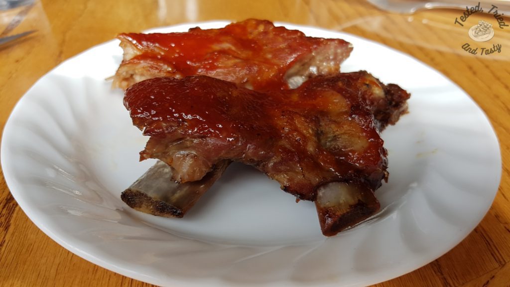Barbecue ribs on a white plate on a wooden table