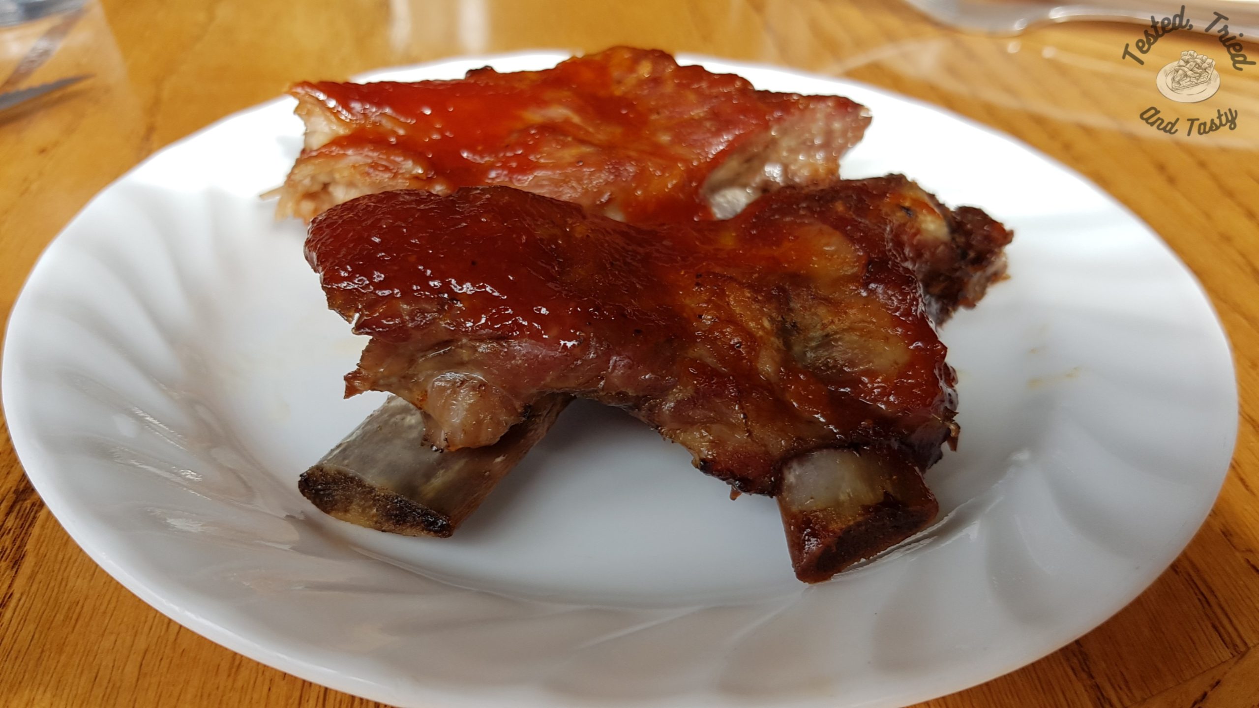 Barbecue ribs on a white plate on a wooden table