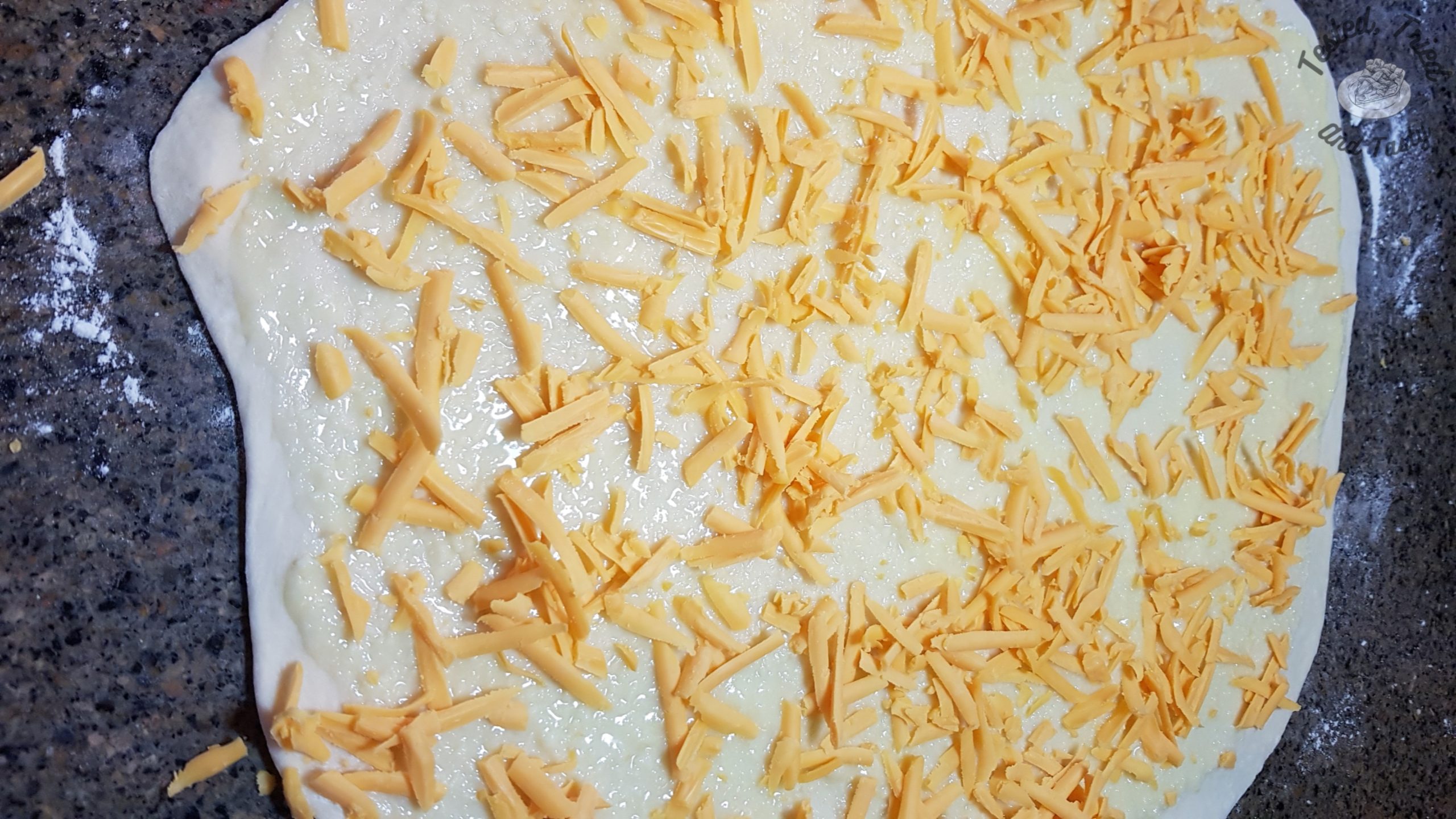sharp cheddar cheese sprinkled on dough for garlic cheese buns
