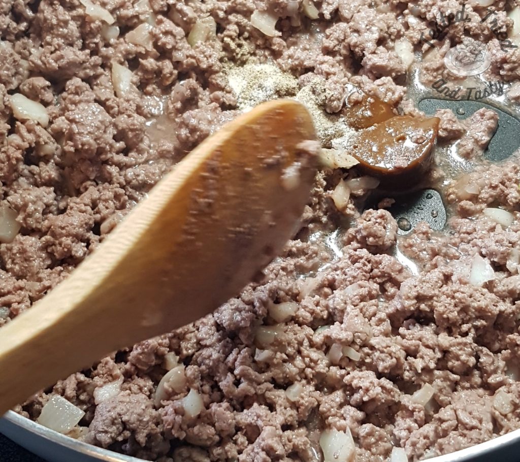 cooking ground beef and onions in a frying pan.