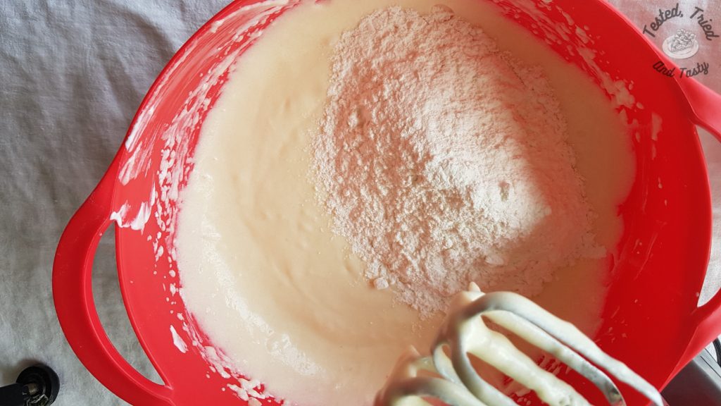 adding dry ingredients to liquid ingredients for vanilla cupcakes