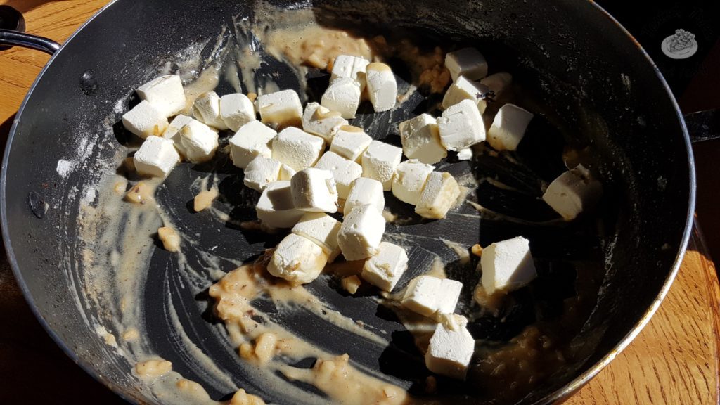 Cream cheese added to butter, garlic and flour in a saucepan.