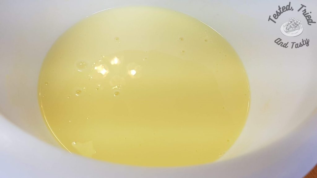 Vanilla pudding in a white plastic bowl.