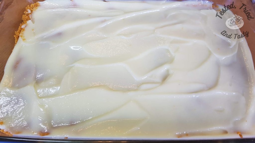 A layer of vanilla pudding spread on a graham crumb crust.
