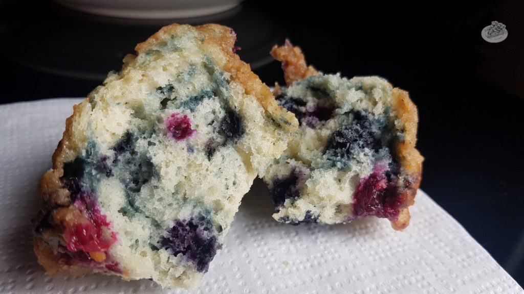 Blueberry muffin with streusel topping on a white napkin.