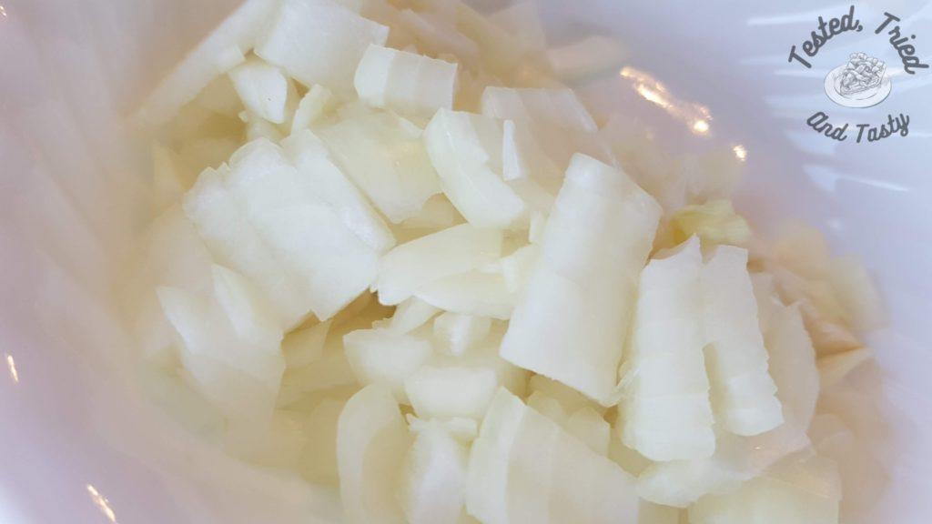 Chopped onions in a white bowl.