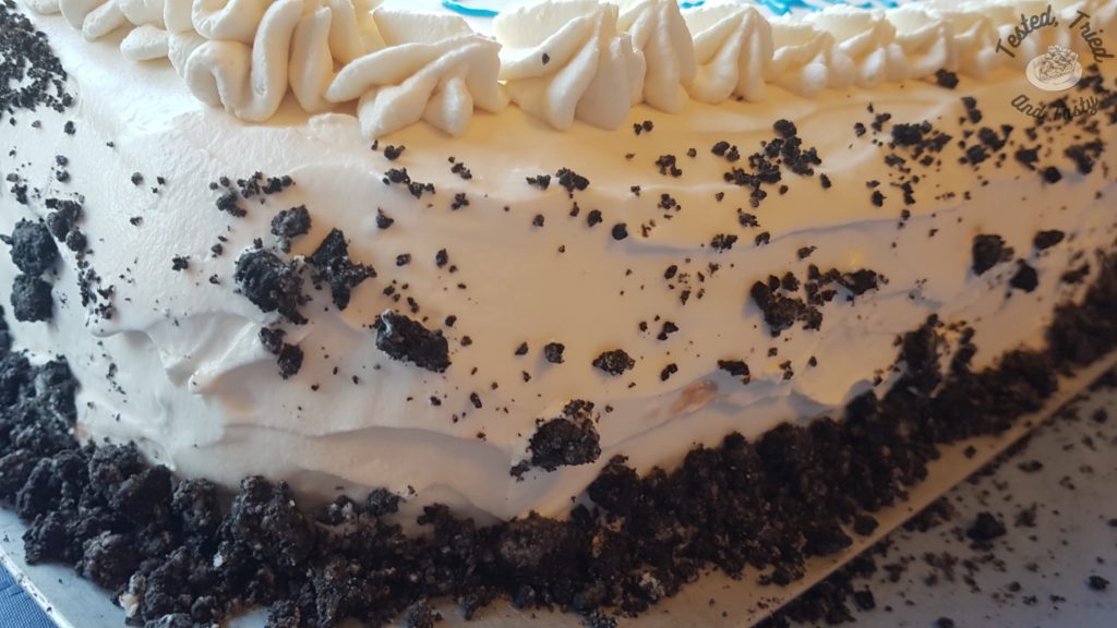 Side view of crushed oreos on the whipping cream.