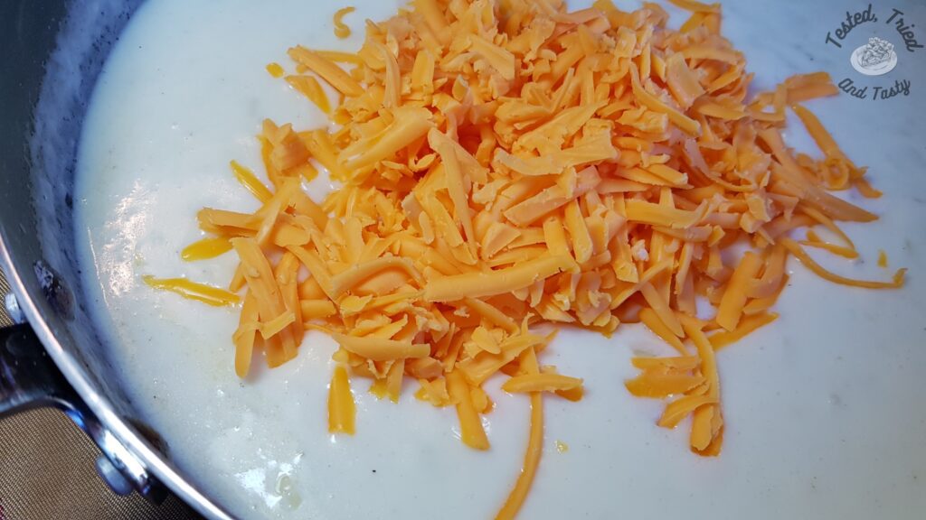 Adding cheddar cheese to the bechamel sauce to create a mornay sauce.