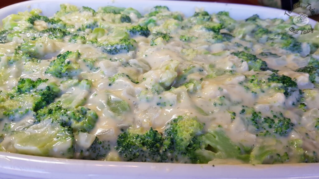 Broccoli with mornay sauce in a white casserole dish.