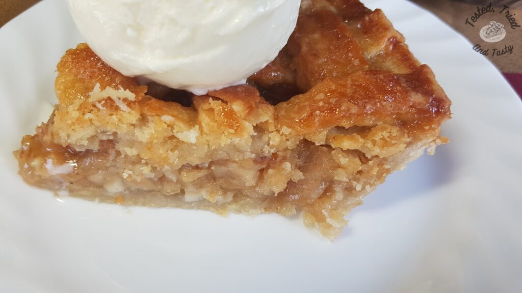 Slice of caramel apple pie on a white plate.