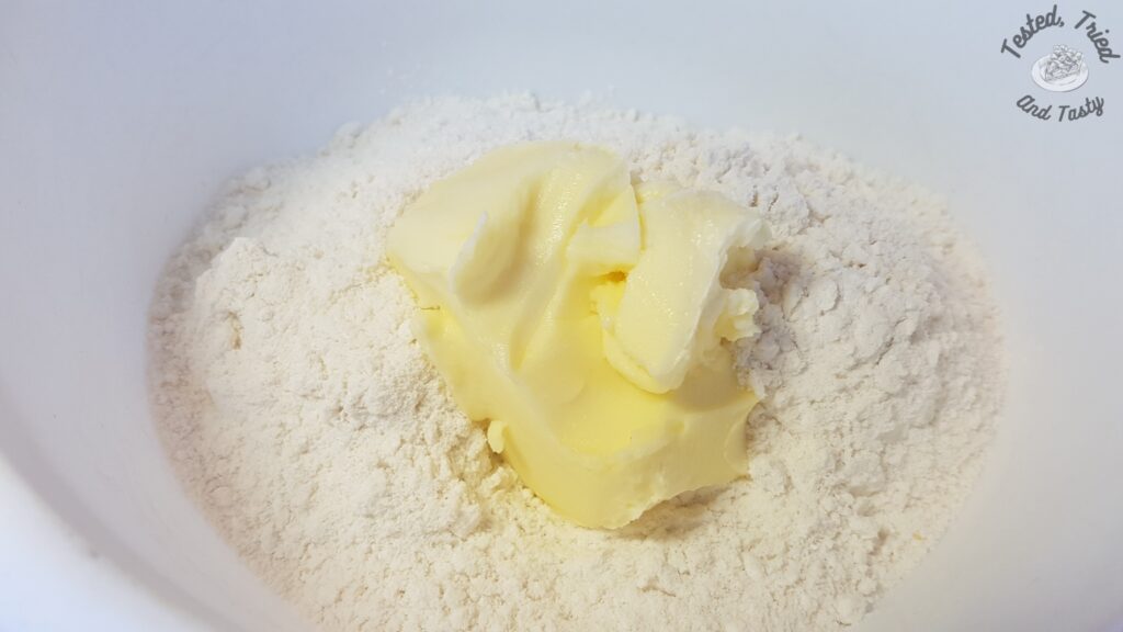 Cake mix and butter in a white bowl.