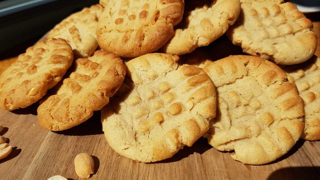 Peanut butter cookies on a wood cutting board.