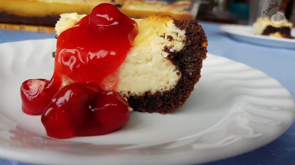 Black Forest cheesecake cake with cherry pie filling on top.