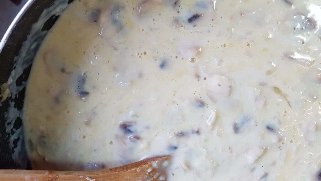 Milk added to the thickened onions and mushrooms