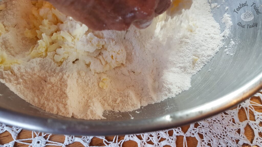 Mixing the frozen grated butter into the dry ingredients.