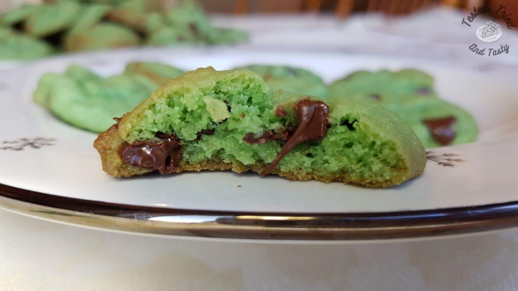 A bite out of a mint chocolate chip cookie.