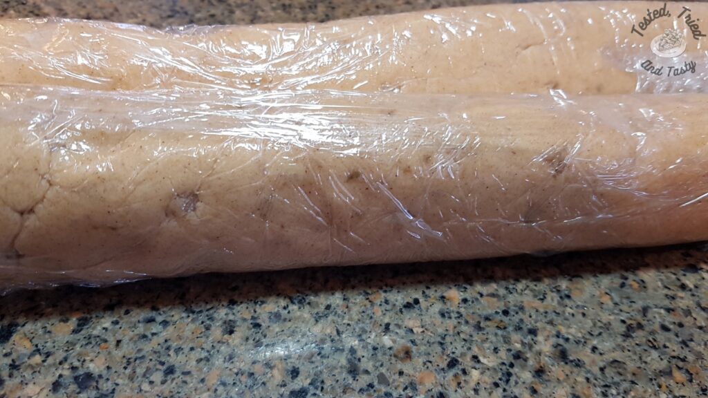 Icebox gingersnap batter formed into a log and wrapped in plastic wrap.