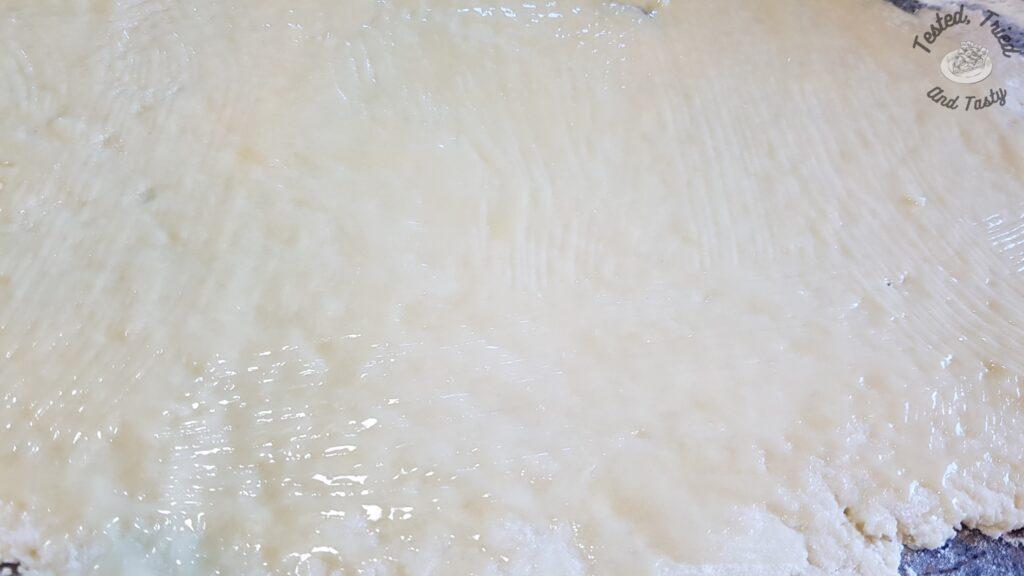 Melted butter spread on the dough.