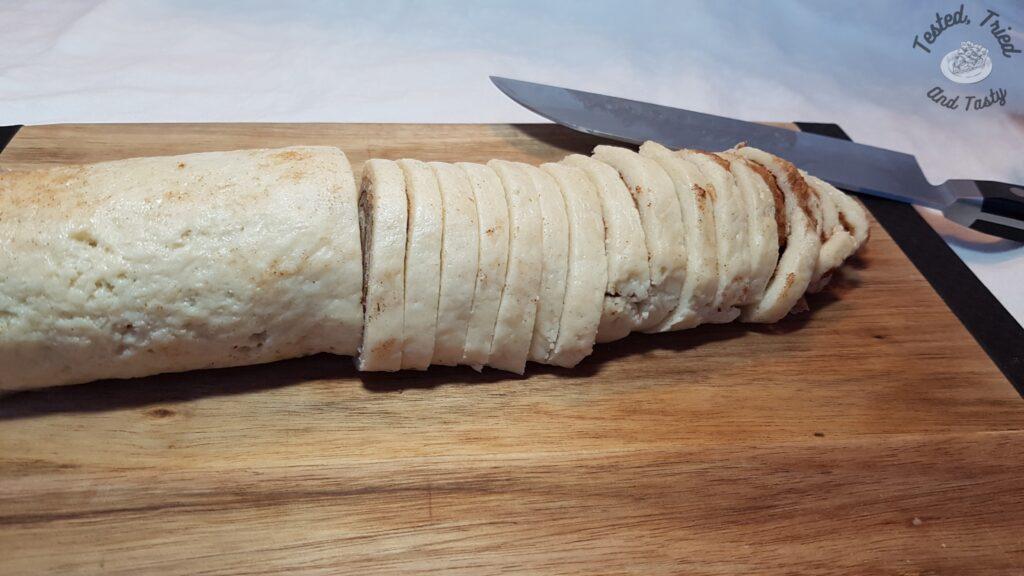 Cookie dough being sliced for baking.