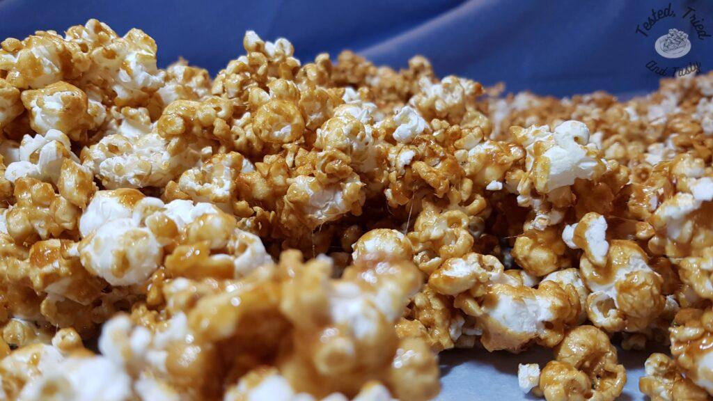 Sweet and crunchy caramel corn on a blue tablecloth.