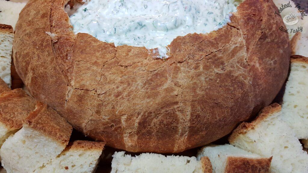 Spinach dip in a sourdough bread loaf.