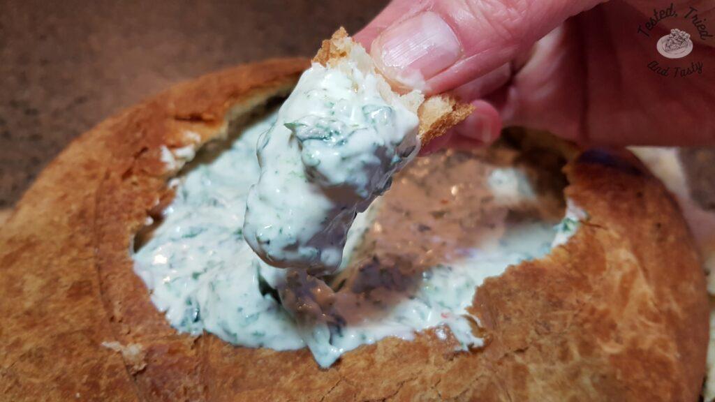 Spinach dip in a sourdough bread loaf.