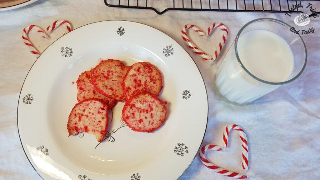 Candy cane icebox cookies on a plate with a glass of milk.