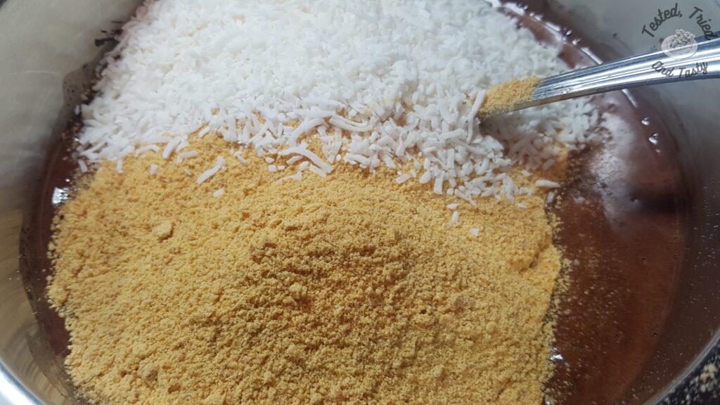 Graham crumbs and coconut added to a saucepan with fudge sauce.