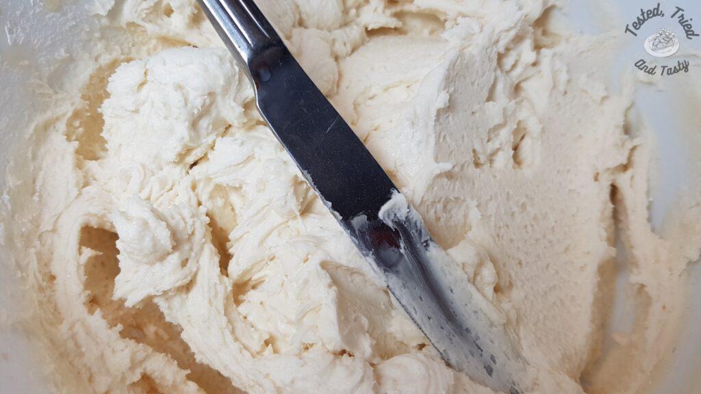 Vanilla icing in a white bowl.