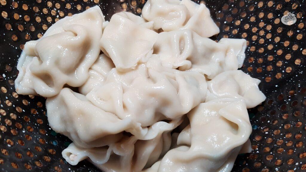 Cooked wontons in a strainer.