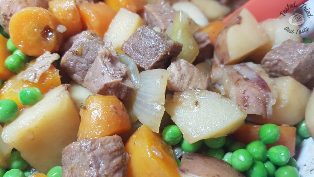 Slow cooker beef stew in a white bowl.