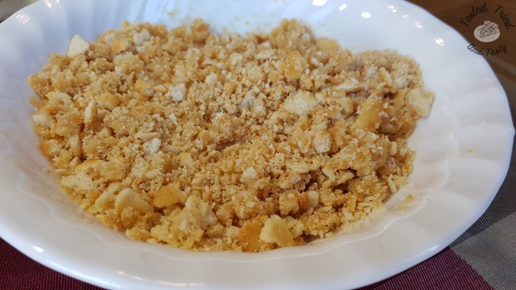 Crushed ritz crackers in a white bowl.
