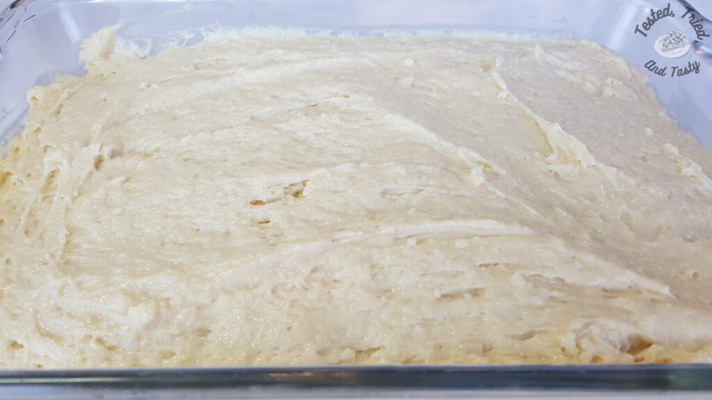 Vanilla cake batter spread into a greased 9x13 inch pan.