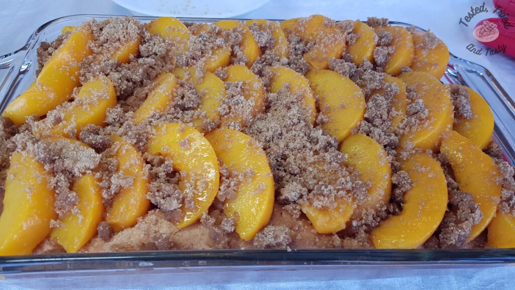 Cinnamon sugar mixture on top of peach slices for peach kuga