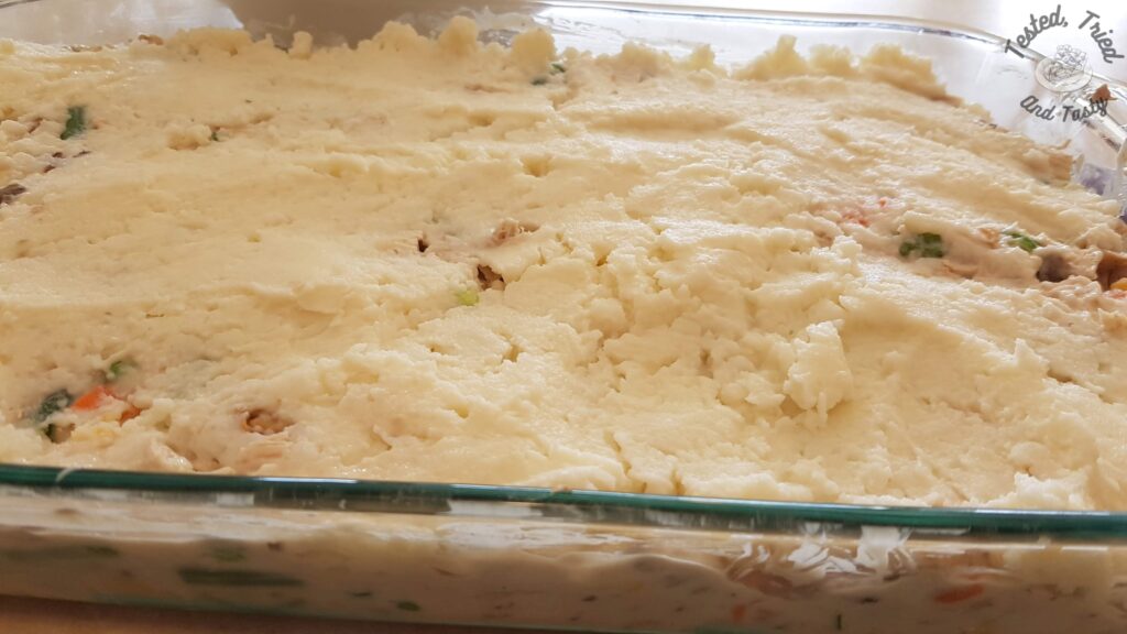 Mashed potatoes on top of the turkey and gravy mixture.