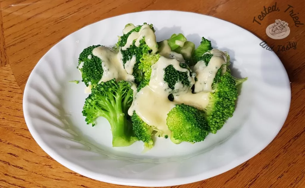 easy cheesy sauce for broccoli on broccoli on a white plate on a table