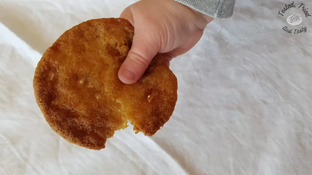 Sweet and Chewy Toffee Cookies being held by a cute hand.