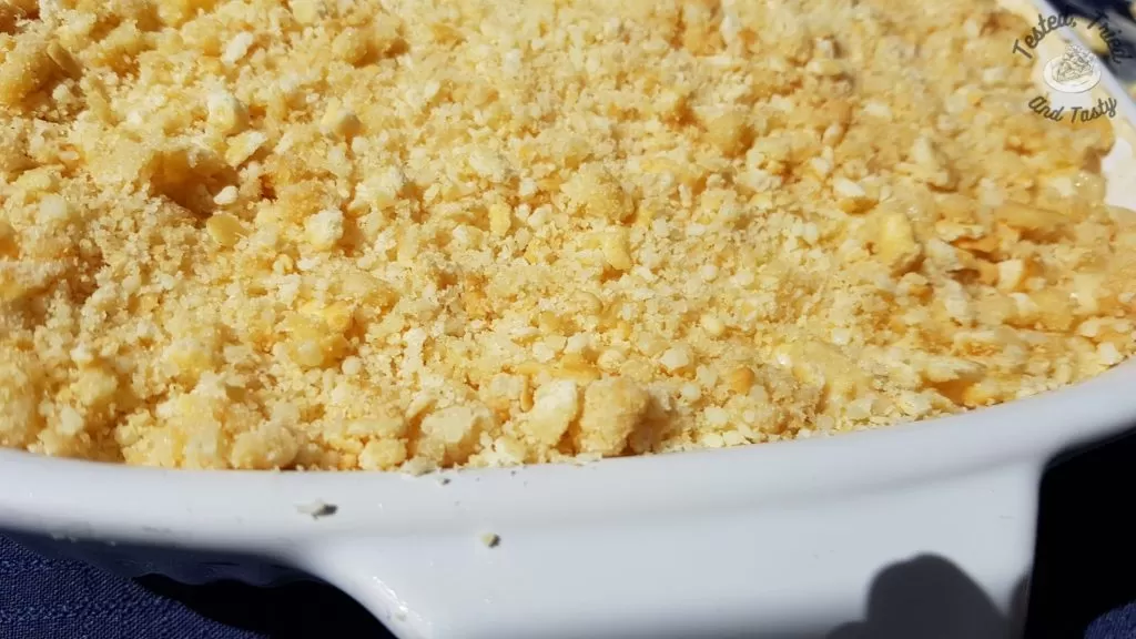 Creamy baked macaroni and cheese in a glass casserole dish.