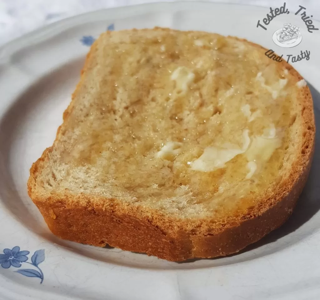 Almost Whole Wheat Bread with butter and honey on a plate. 