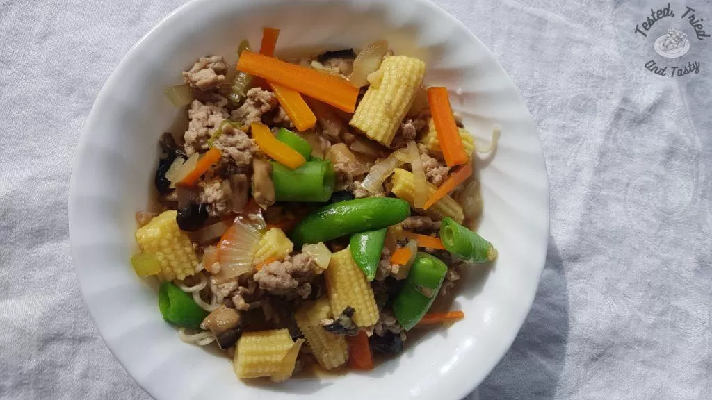 Oriental Pork and noodle soup in a white bowl on a white tablecloth