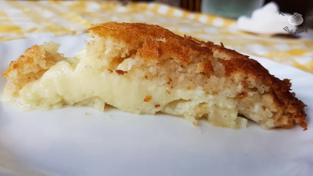 Impossible Pie on a white plate on a yellow and checkered tablecloth.