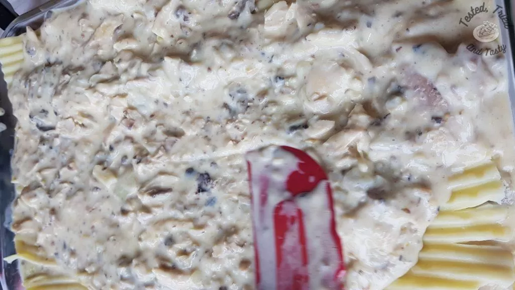 Creamy chicken lasagna being made.