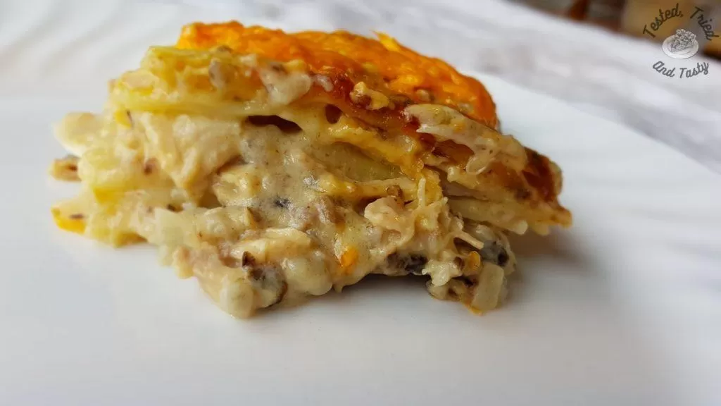 creamy chicken lasagne on a white plate on a white tablecloth.