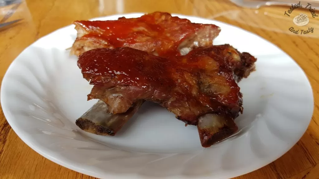 Barbecue ribs on a white plate on a wooden table