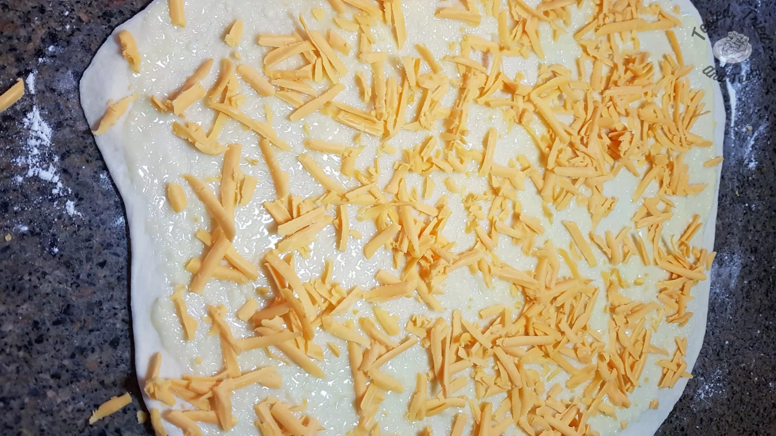 sharp cheddar cheese sprinkled on dough for garlic cheese buns