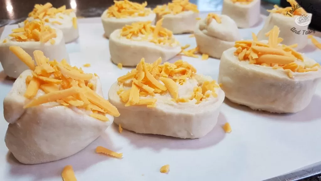 garlic cheese buns on parchment paper before rising