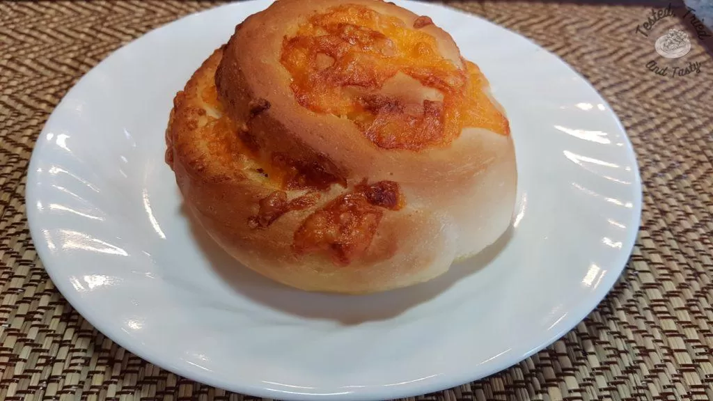 garlic cheese bun on a white plate on a bamboo placemat